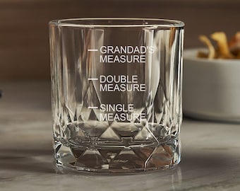 May include: A clear, diamond-cut glass with etched measurement lines labeled "Grandad's Measure", "Double Measure", and "Single Measure". The glass is designed for measuring liquids and has a thick base.