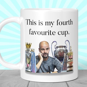 K&ouml;nnte beinhalten: Wei&szlig;e Keramik-Tasse mit Henkel, mit dem Text "This is my fourth favourite cup." Die Tasse zeigt ein Bild eines Mannes und mehrerer Troph&auml;en. Die Tasse hat eine Standardgr&ouml;&szlig;e von etwa 325 ml.