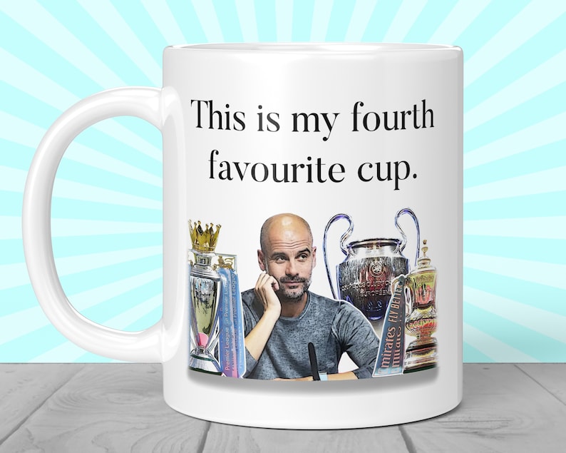 K&ouml;nnte beinhalten: Wei&szlig;e Keramik-Tasse mit Henkel, mit dem Text "This is my fourth favourite cup." Die Tasse zeigt ein Bild eines Mannes und mehrerer Troph&auml;en. Die Tasse hat eine Standardgr&ouml;&szlig;e von etwa 325 ml.