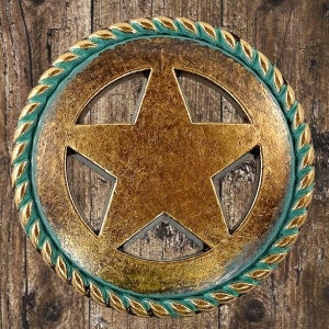 May include: A gold-toned metal star with a cutout design, surrounded by a green and gold rope-like border.