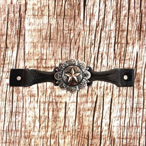 May include: Black cast iron doorstop with a silver star and starburst design.