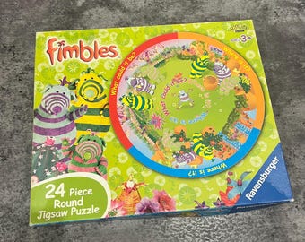 May include: A 24-piece round jigsaw puzzle featuring characters from Fimbles. The puzzle has a colorful circular design with the text "Where is it?" and "What could it be?" on the puzzle. The box has the Fimbles logo and the Ravensburger logo.
