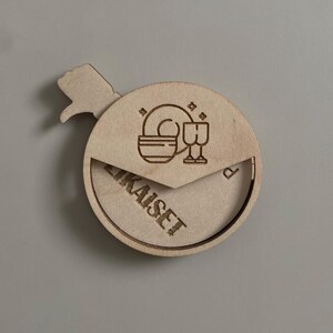 May include: A wooden round sign with a hand pointing to the right. The sign says "ZIKAISE" and has a design of a plate and two glasses.