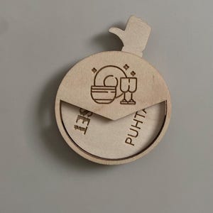May include: A wooden box with a thumbs up design on the top. The box is engraved with the words "Puhti" and "Set" and a graphic of a plate and glasses.