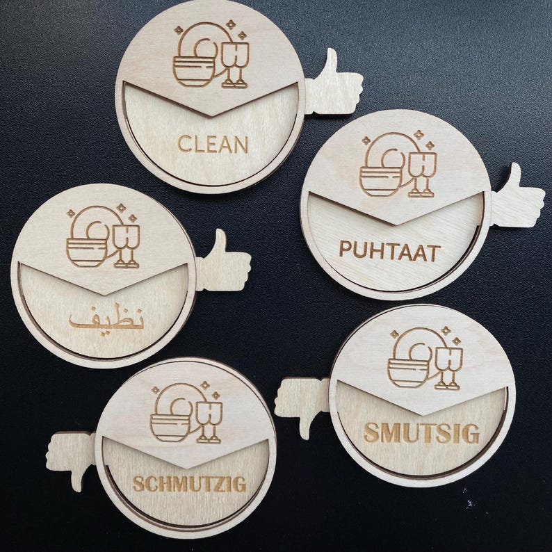 May include: Five wooden round signs with thumbs up and down indicators. The signs have different words and symbols indicating clean or dirty dishes. The words are "Clean", "Puhtaat", "Nظيف", "Schmutzig", and "Smutsig".