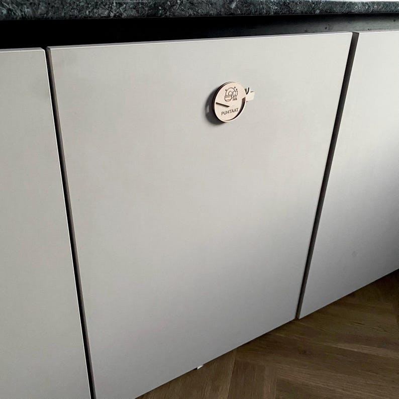 May include: A white cabinet door with a wooden knob featuring a stylized design and the word "Puhtaat" written on it.