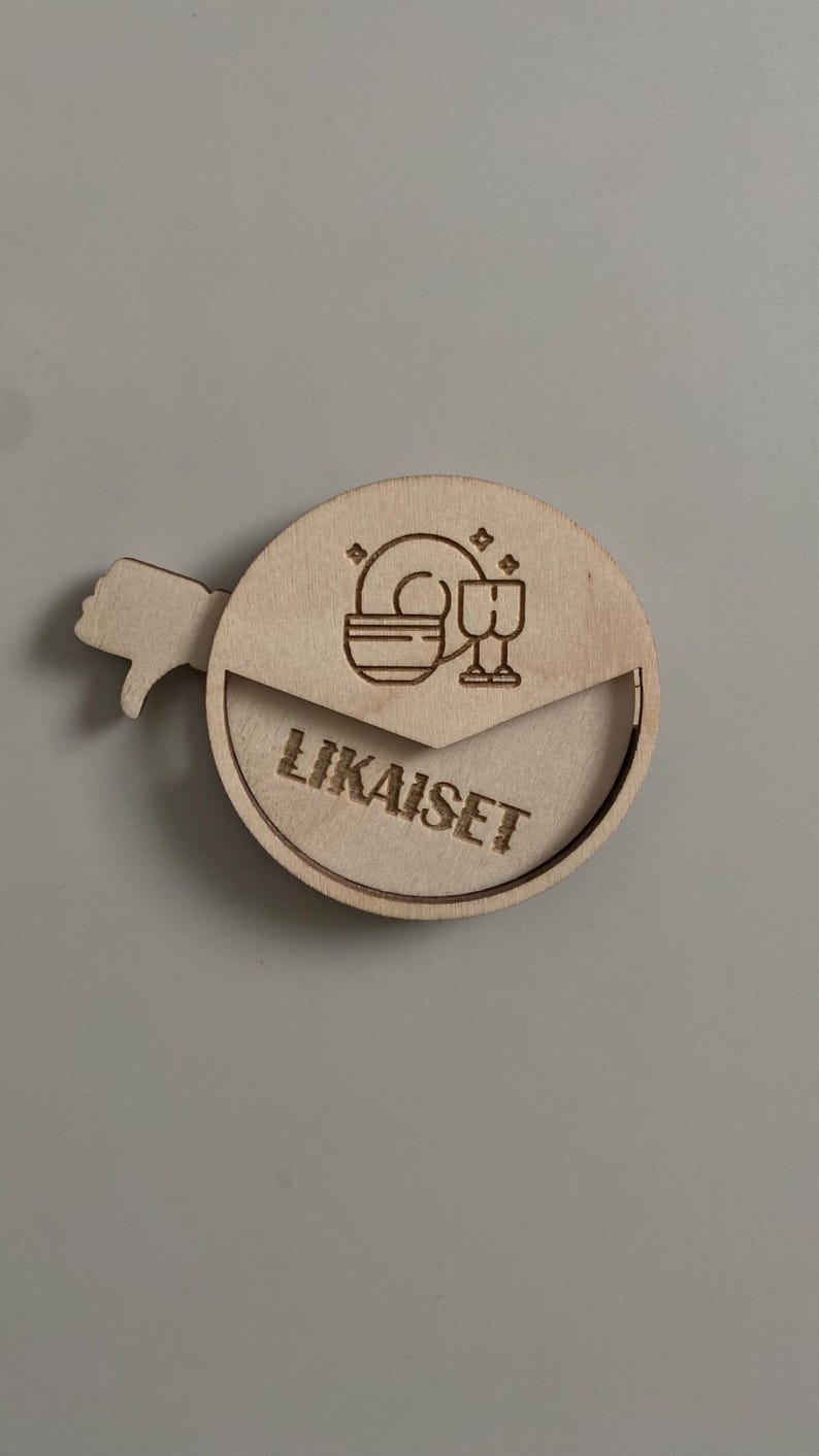 May include: A wooden round sign with a thumbs down icon and the text "LIKAISET" in a circle. The sign has a small cutout in the shape of a plate and two glasses.
