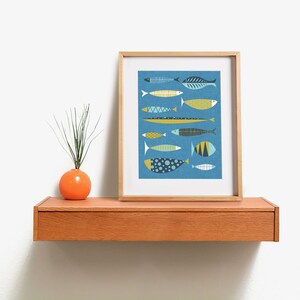 May include: A framed print of a blue background with a collection of stylized fish in various colors and patterns. The fish are arranged in a vertical row, with the largest fish at the bottom and the smallest fish at the top.