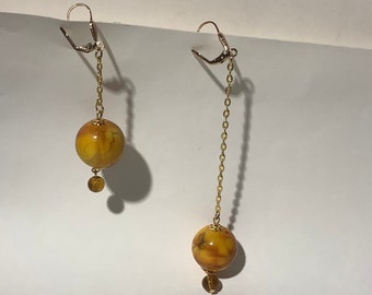 Asymmetrical, gold earrings with marbled pearl yellow tones