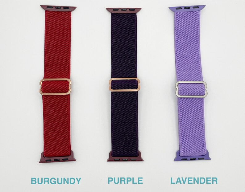 May include: Three Apple Watch bands in different colours: burgundy, purple, and lavender. Each band has a metal clasp.