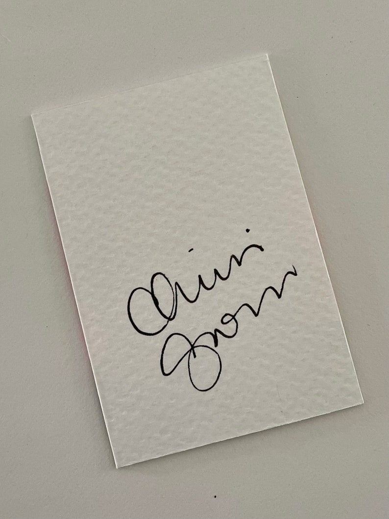 May include: A white card with black cursive writing that says "Love from" on it.