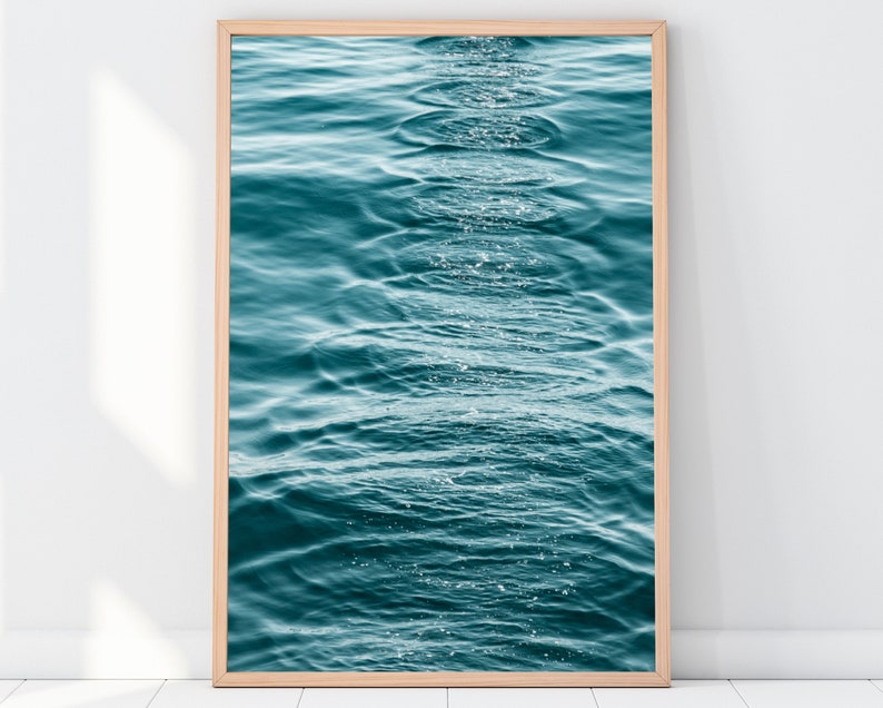 May include: A close-up photo of rippling turquoise water with sunlight reflecting on the surface.