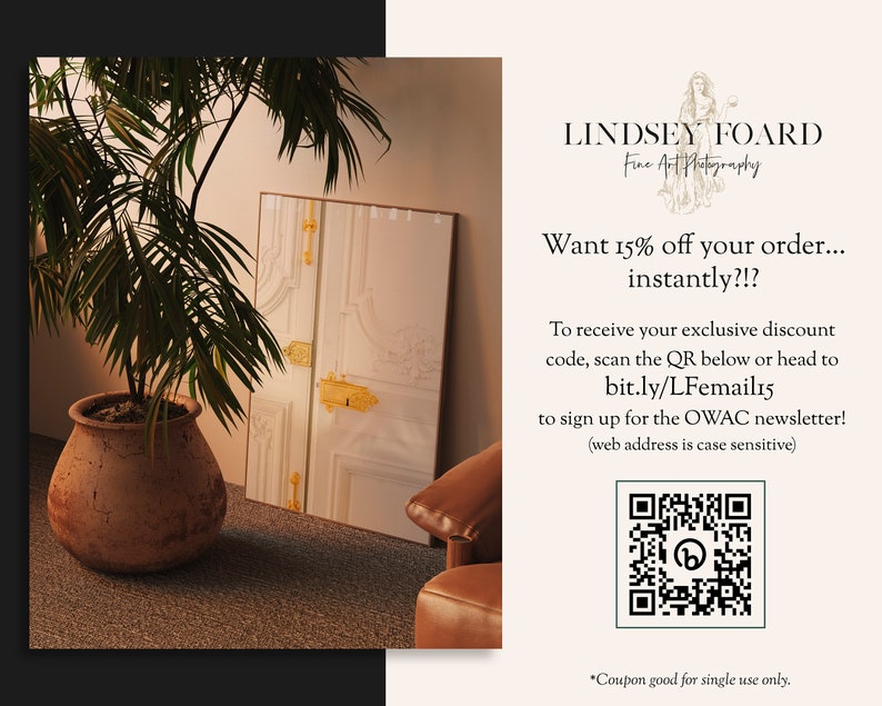 Op de afbeelding: Een witte deur met gouden accenten is ingelijst tegen een witte muur. Op de voorgrond staan een potplant met een palmboom en een bruine leren stoel. De tekst op de afbeelding luidt: "Lindsey Foard Fine Art Photography Want 15% off your order... instantly?!? To receive your exclusive discount code, scan the QR below or head to bit.ly/LFemail15 to sign up for the OWAC newsletter! (web address is case sensitive) *Coupon good for single use only."