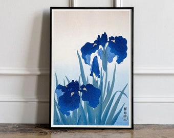 Peut inclure: Une estampe encadrée d'une peinture de style japonais représentant trois iris bleus avec des feuilles vertes sur un fond blanc. L'estampe est signée en caractères japonais.