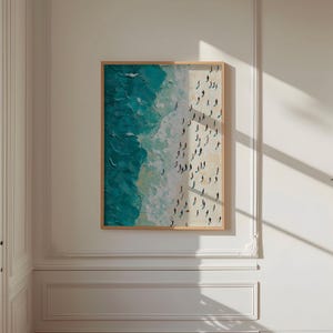 May include: A framed painting depicting an aerial view of a beach with turquoise water and white sand. The painting shows many small figures of people on the beach.