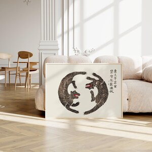 May include: A black and white print of two stylized animals facing each other in a circle. The animals are in a dynamic pose, with their tails intertwined. The print is on a white background and has a light beige frame. The text in the image reads: "The Great Sage Says: "The Wise One's Mind Is Like A Mirror."