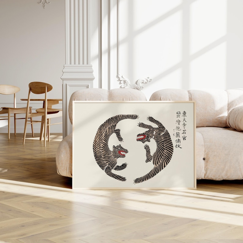 May include: A black and white print of two stylized animals facing each other in a circle. The animals are in a dynamic pose, with their tails intertwined. The print is on a white background and has a light beige frame. The text in the image reads: "The Great Sage Says: "The Wise One's Mind Is Like A Mirror."
