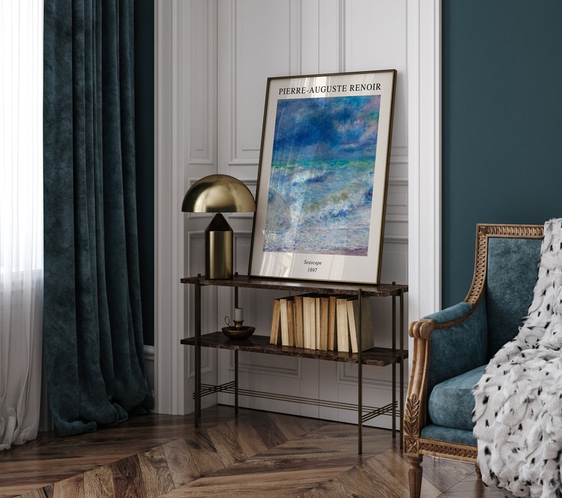 May include: A framed print of a seascape painting by Pierre-Auguste Renoir. The painting depicts a stormy sea with blue and green hues. The frame is gold and the print is titled "Seascape 1887".