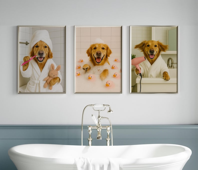 May include: Set of three framed prints featuring Golden Retrievers in a bathroom setting. One dog brushes its teeth, another bathes with rubber ducks, and the third dries its fur with a hairdryer. Each dog wears a white robe.