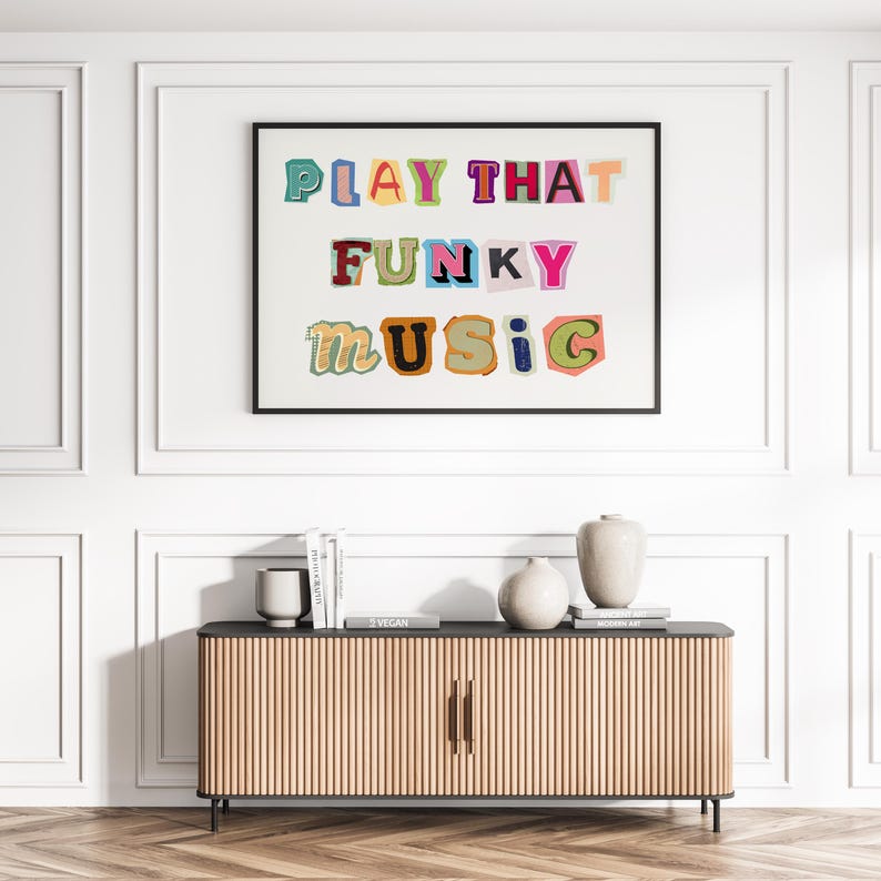 Puede incluir: Una impresi&oacute;n enmarcada con el texto "PLAY THAT FUNKY MUSIC" en letras de colores recortadas sobre un fondo blanco.