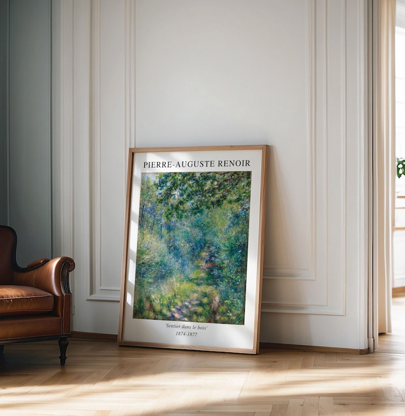 K&ouml;nnte beinhalten: Ein gerahmter Kunstdruck eines Gem&auml;ldes von Pierre-Auguste Renoir mit dem Titel "Sentier dans le bois" (1874-1877). Das Gem&auml;lde zeigt einen Weg durch einen &uuml;ppigen gr&uuml;nen Wald mit durchscheinendem Sonnenlicht.