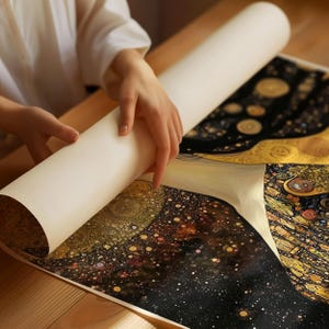 May include: A person unrolling a print of a famous painting. The print features a black and gold background with a swirling pattern of stars and dots. The print is rolled up and being unrolled by a person's hand.