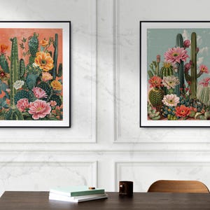 May include: Two framed prints of vintage botanical illustrations featuring cacti and flowers in shades of pink, orange, and green. The prints are set against a white wall with a vase and a wooden table in the foreground.