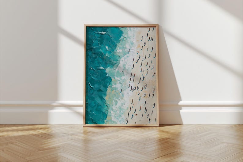 May include: A framed painting depicting a beach scene with turquoise water and white sand. The painting shows a large group of people on the beach, viewed from above.