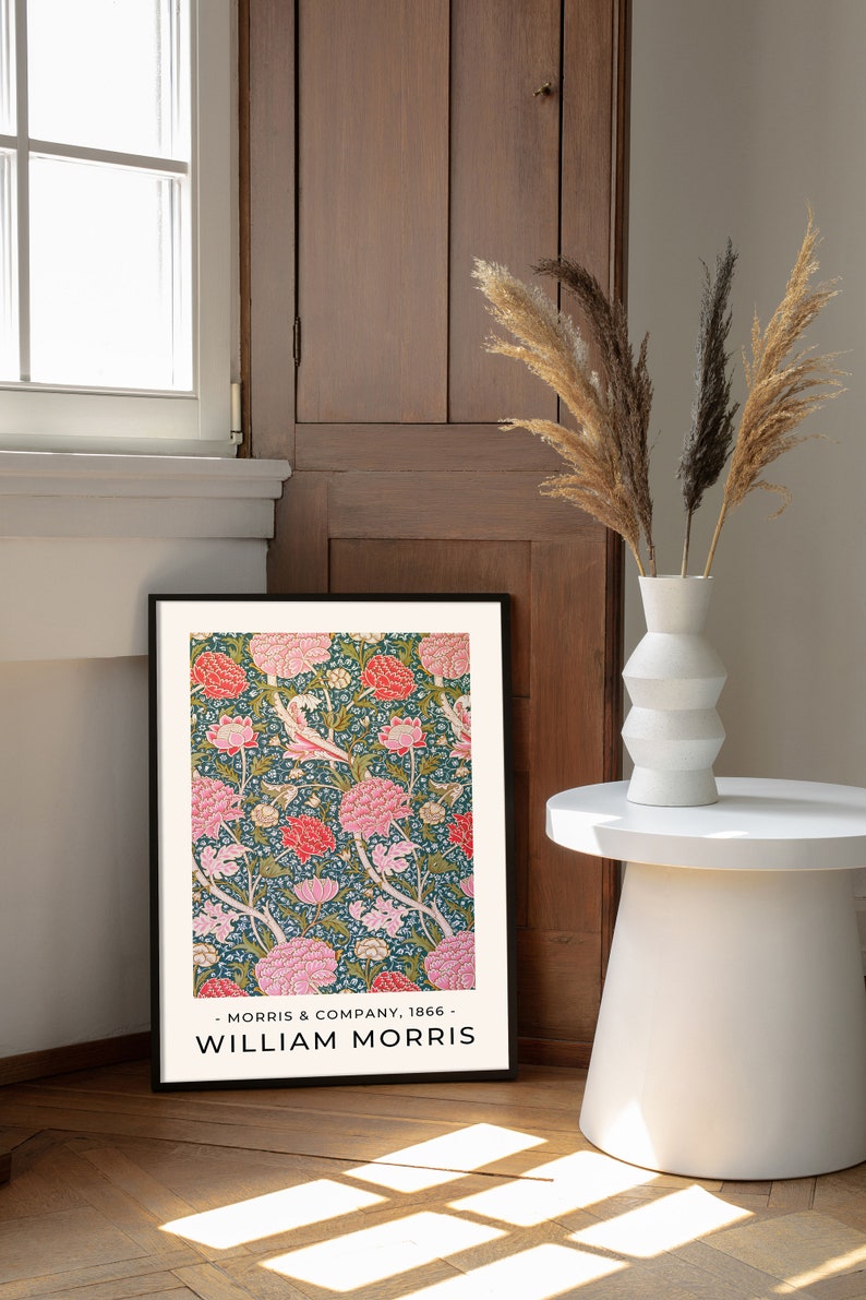 K&ouml;nnte beinhalten: Ein gerahmter Druck eines Blumenmusters mit rosa und wei&szlig;en Bl&uuml;ten auf dunkelgr&uuml;nem Hintergrund. Der Druck ist mit "William Morris" betitelt und enth&auml;lt den Text "Morris & Company, 1866".