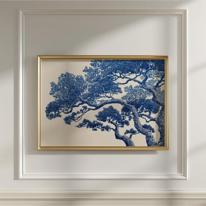 May include: A framed art print with a detailed blue and white tree illustration. The artwork is set against a cream background and enclosed in a gold-coloured frame. The image is mounted on a white wall.