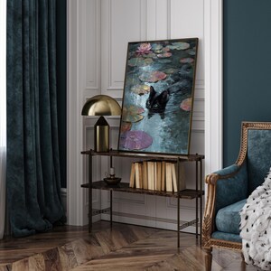 May include: An interior scene featuring a framed painting of a black cat in a pond with lily pads and flowers. A gold lamp and a shelf with books and a candle holder are also visible. The room has dark teal curtains and a patterned wooden floor.