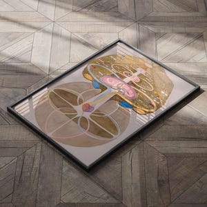May include: A framed illustration of a tree with a complex, circular design. The tree is depicted in shades of brown, yellow, and pink, with blue and red accents. The background is a light brown wood grain.