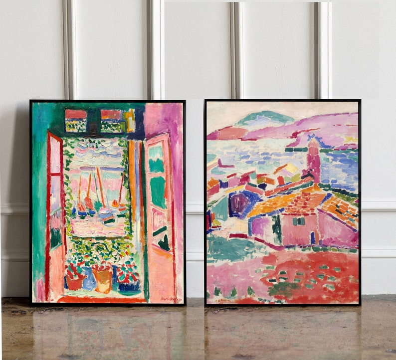May include: Two framed paintings of colorful abstract landscapes. The painting on the left shows a window with a view of a harbor with boats. The painting on the right shows a village with houses and a body of water in the background.