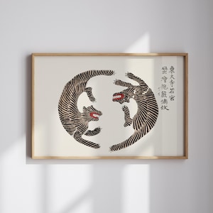 May include: A black and white print of two stylized tigers facing each other in a circle. The print is framed in a light wood frame. The text in the image reads "東 大寺 法隆寺".