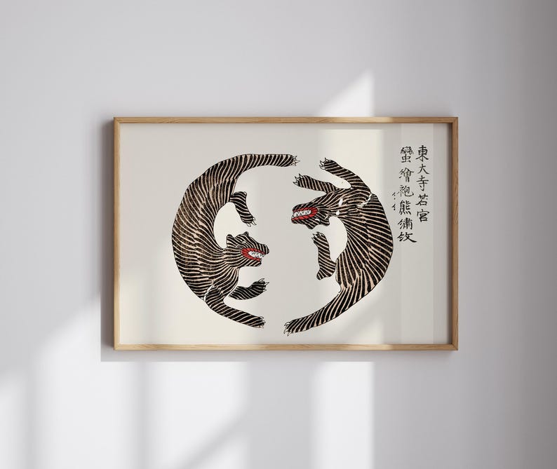 May include: A black and white print of two stylized tigers facing each other in a circle. The print is framed in a light wood frame. The text in the image reads "東 大寺 法隆寺".