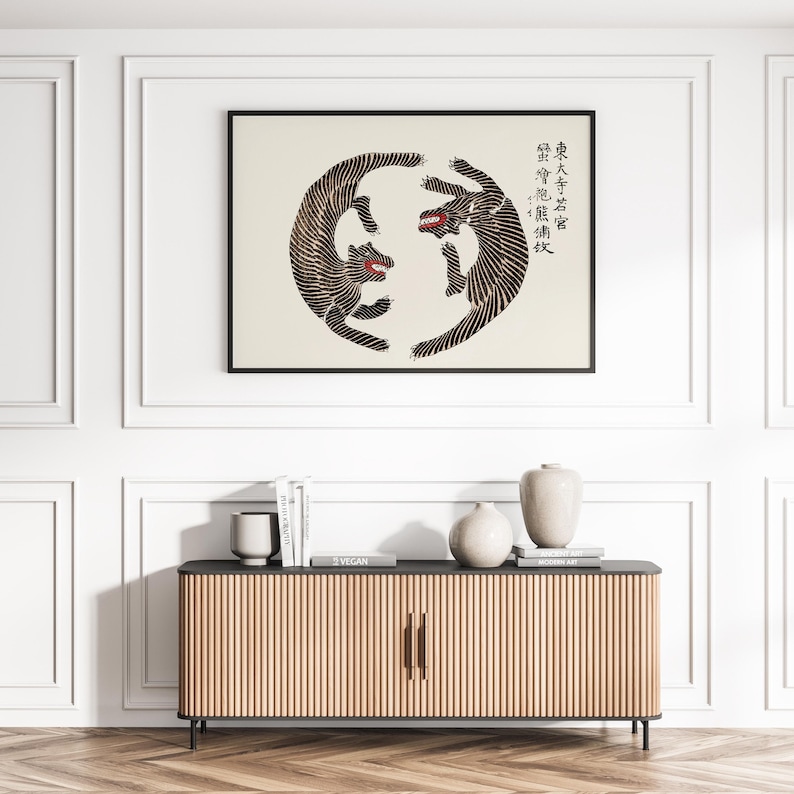 May include: A black and white illustration of two tigers facing each other in a circle. The tigers are stylized and have a geometric pattern. The background is white and the image is framed in a black frame. The text in the image reads "君子成人之美, 勿成人之恶".