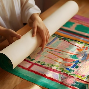 Puede incluir: Una persona desenrollando una pintura abstracta colorida sobre una superficie de madera. La pintura presenta colores vibrantes como verde, rosa, naranja y azul, creando una obra de arte din&aacute;mica y expresiva.