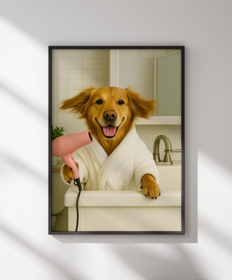 May include: Framed print featuring a Golden Retriever dog in a white bathrobe, holding a pink hairdryer. The dog is smiling with its tongue out, appearing to be in a bathroom setting. The image is framed in a black border.