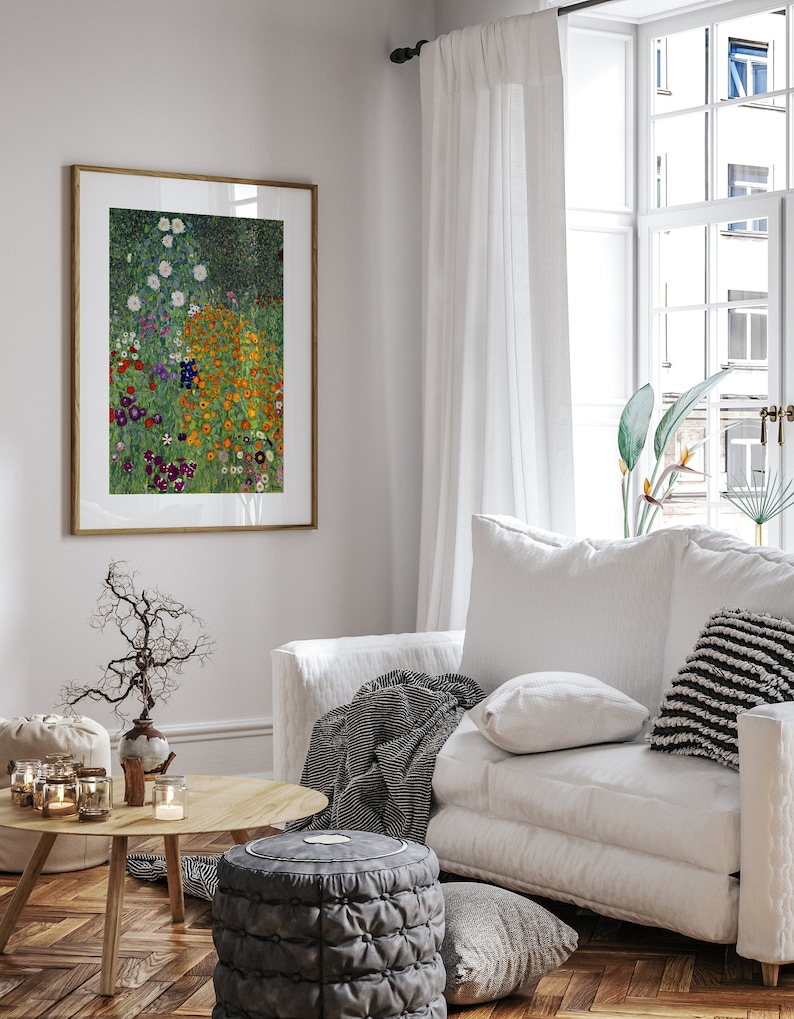May include: A framed print of a painting depicting a field of colorful flowers in shades of orange, yellow, purple, and white. The flowers are arranged in a random pattern against a green background. The print is hanging on a white wall in a living room setting.
