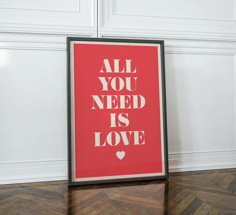 May include: A framed poster with a red background and white text that reads "All You Need Is Love". A small white heart is in the bottom center of the poster.