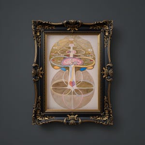 May include: A framed print of a colorful, abstract illustration depicting a tree with a heart at its center. The tree is surrounded by concentric circles and other geometric shapes. The artwork is framed in a black and gold ornate frame.