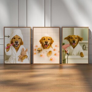 May include: Three framed prints featuring a golden retriever in a bathroom setting. One dog is brushing its teeth, another is in a bubble bath with rubber ducks, and the third is using a hairdryer. Each dog wears a white robe.