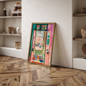 Puede incluir: Una pintura enmarcada que representa una escena de ventana abstracta y colorida con vistas a barcos y un jard&iacute;n. La pintura est&aacute; en un marco de madera claro y tiene un borde verde.