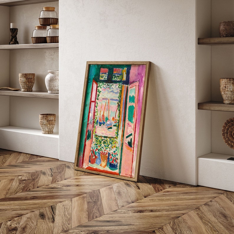 Puede incluir: Una pintura enmarcada que representa una escena de ventana abstracta y colorida con vistas a barcos y un jard&iacute;n. La pintura est&aacute; en un marco de madera claro y tiene un borde verde.