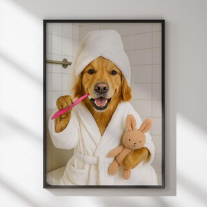 May include: A framed print featuring a Golden Retriever wearing a white bathrobe and towel, brushing its teeth with a pink toothbrush. The dog holds a small brown stuffed bunny. The background shows a tiled wall.