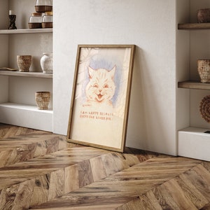 May include: A framed illustration of a white cat with a happy expression. The cat is surrounded by a light blue background with a light brown frame. The text below the cat reads "I am happy because everyone loves me."