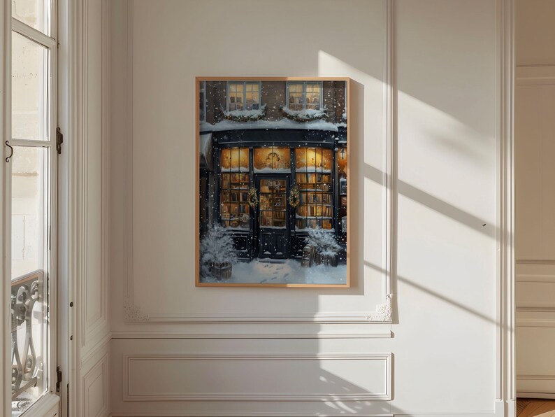 May include: A framed illustration of a storefront with a dark blue door and windows decorated with Christmas lights and wreaths. The storefront is covered in snow and the windows are filled with books.