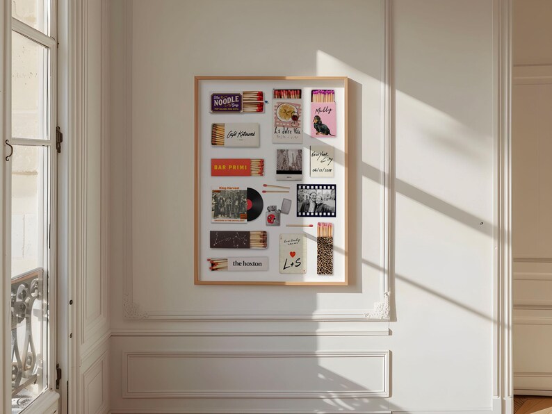 May include: A framed collection of various matchboxes, postcards, and a vinyl record. The matchboxes feature text like "NOODLE SHOP" and "BAR PRIMI". A pink matchbox has a dog illustration. The collection is displayed on a white wall.