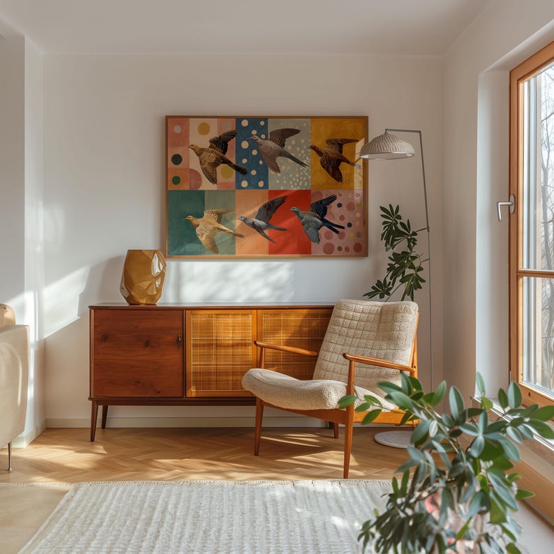Pu&ograve; includere: Un soggiorno in stile moderno di met&agrave; secolo con una credenza in legno, una poltrona a fantasia e una grande opera d'arte con uccelli in volo. Un vaso dorato e una lampada da terra con paralume intrecciato completano l'arredamento. La stanza ha un tappeto e una pianta.