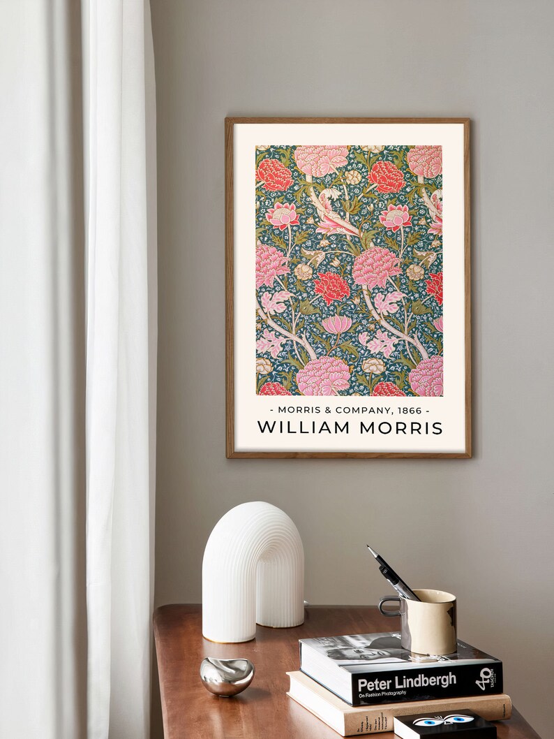 K&ouml;nnte beinhalten: Ein gerahmter Druck eines Blumenmusters in Rosa-, Gr&uuml;n- und Wei&szlig;t&ouml;nen. Der Druck tr&auml;gt den Titel "William Morris" und enth&auml;lt den Text "Morris & Company, 1866".